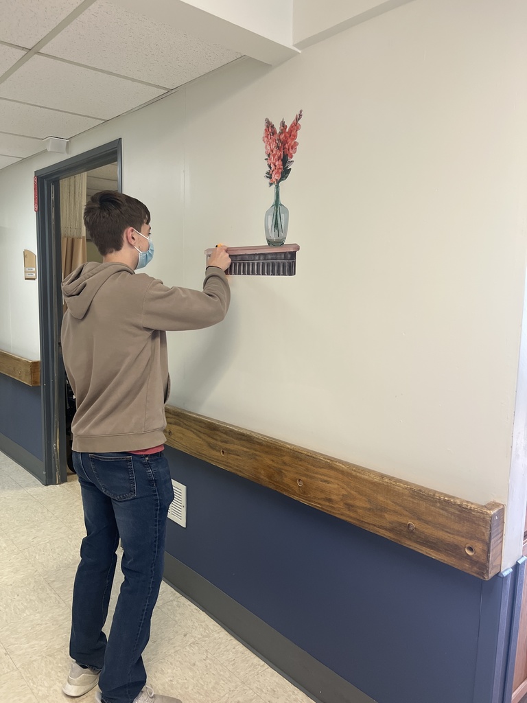 Colby Gray applying a wall shelf.